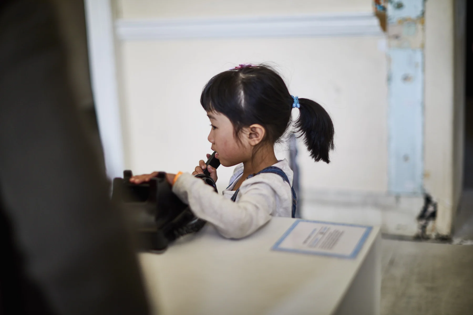 A child speaking into the telephone receiver.