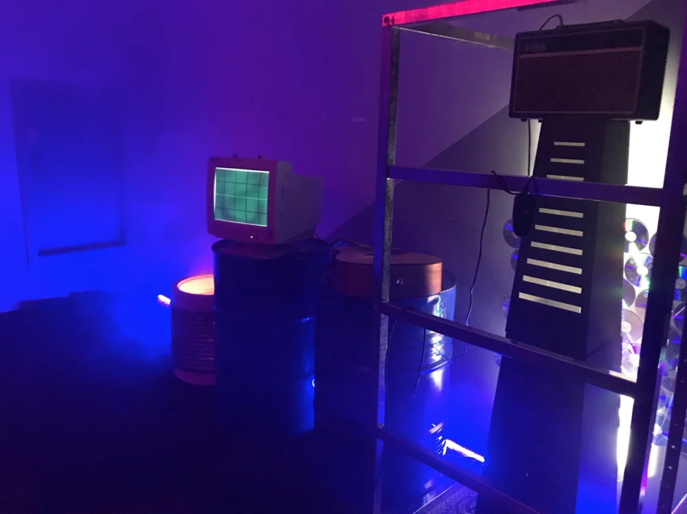 A chair, table and standing lamp washed in blue and pink light.
