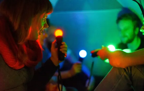 Participants exploring the glowing controllers of Broken Sounds.