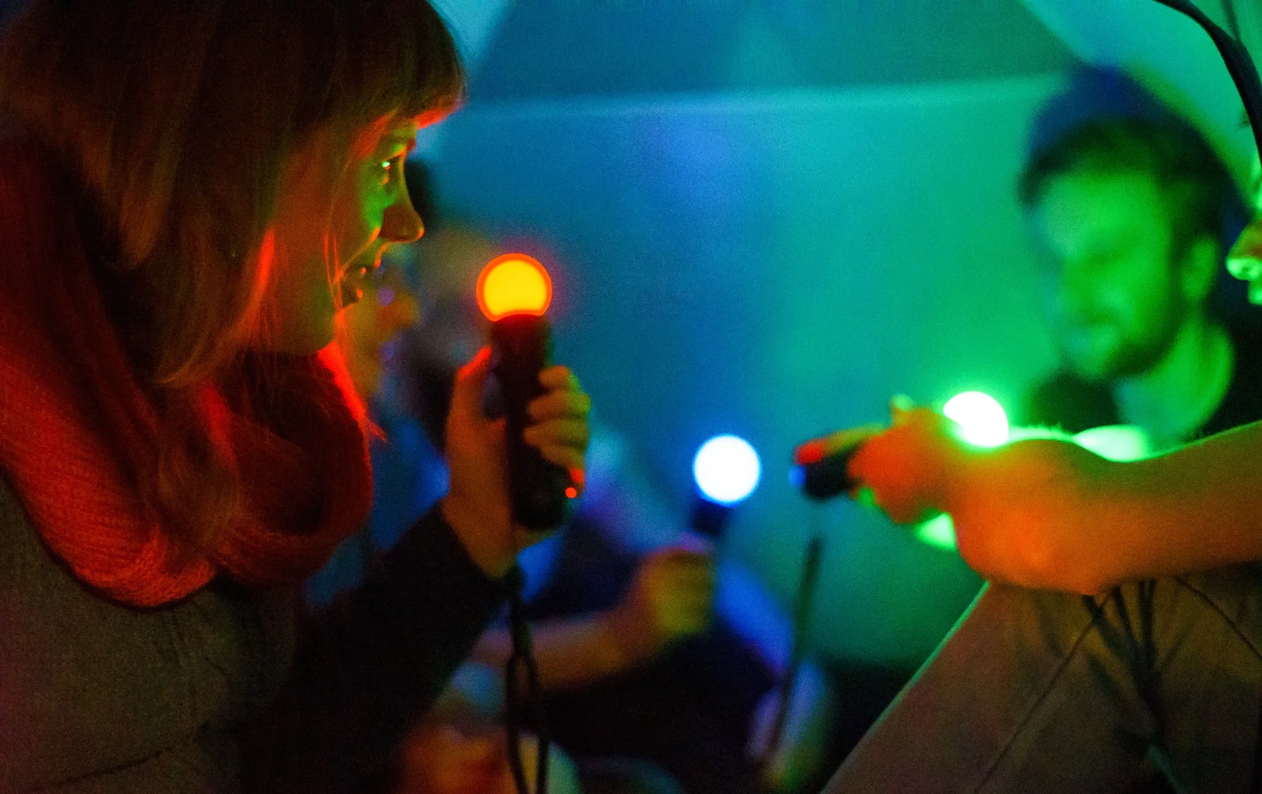 Participants exploring the glowing controllers of Broken Sounds.