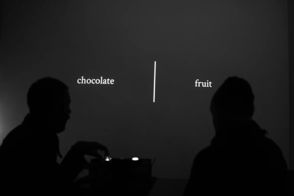 Two silhouettes face a choice between chocolate and fruit.