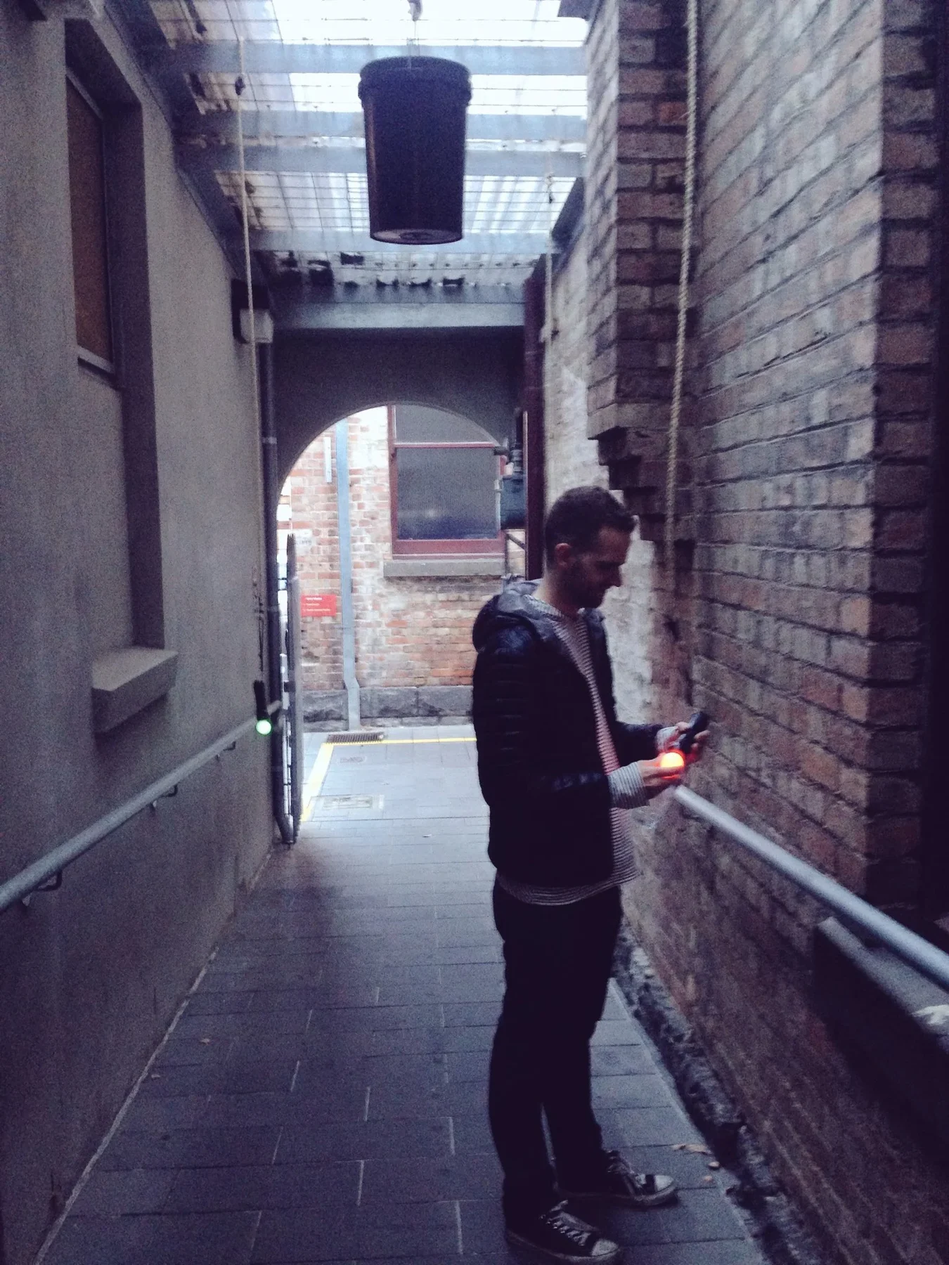 A person standing in a narrow laneway for Broken Sounds.