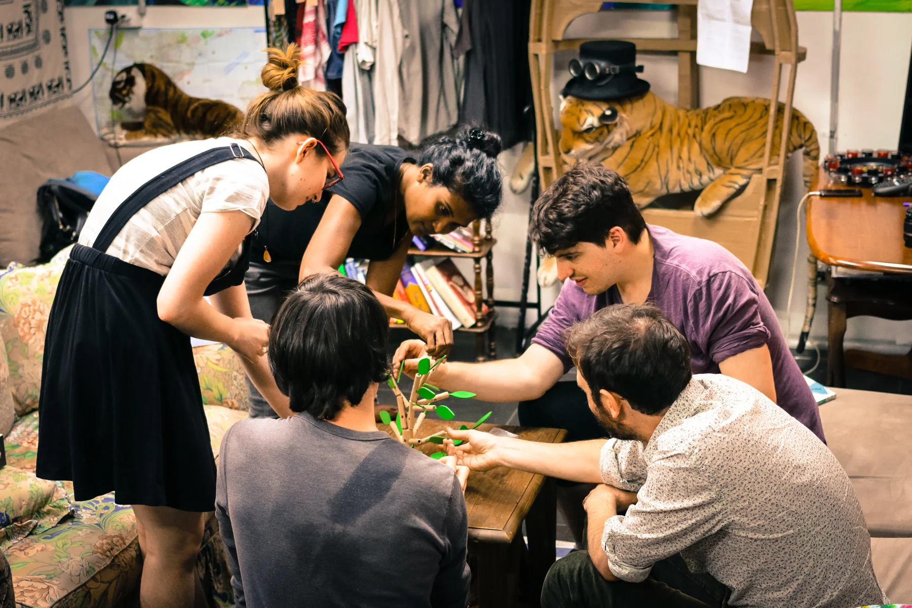 Visitors playing a game around a table at the Inconvenience Store.