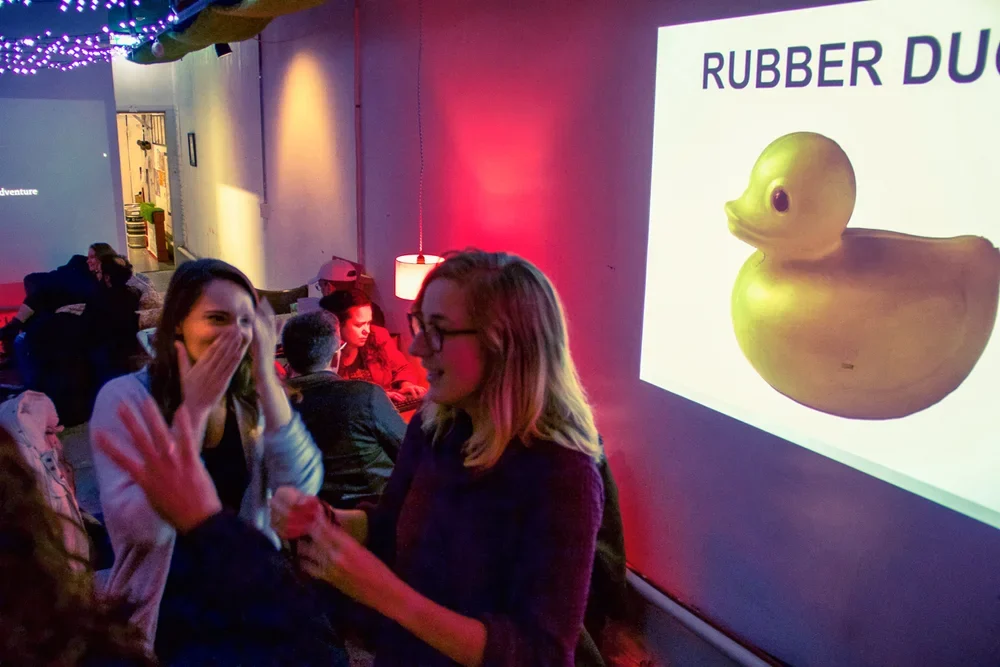 Players guide one another in front of an Object Lesson projection.